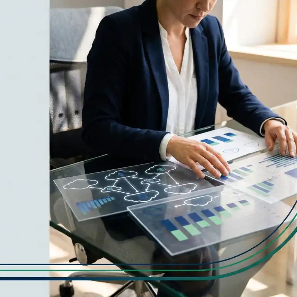 Een zakelijke professional die onder de warme verlichting van een kantoor op een glazen bureau kostenstroomdiagrammen van cloudinfrastructuur analyseert.